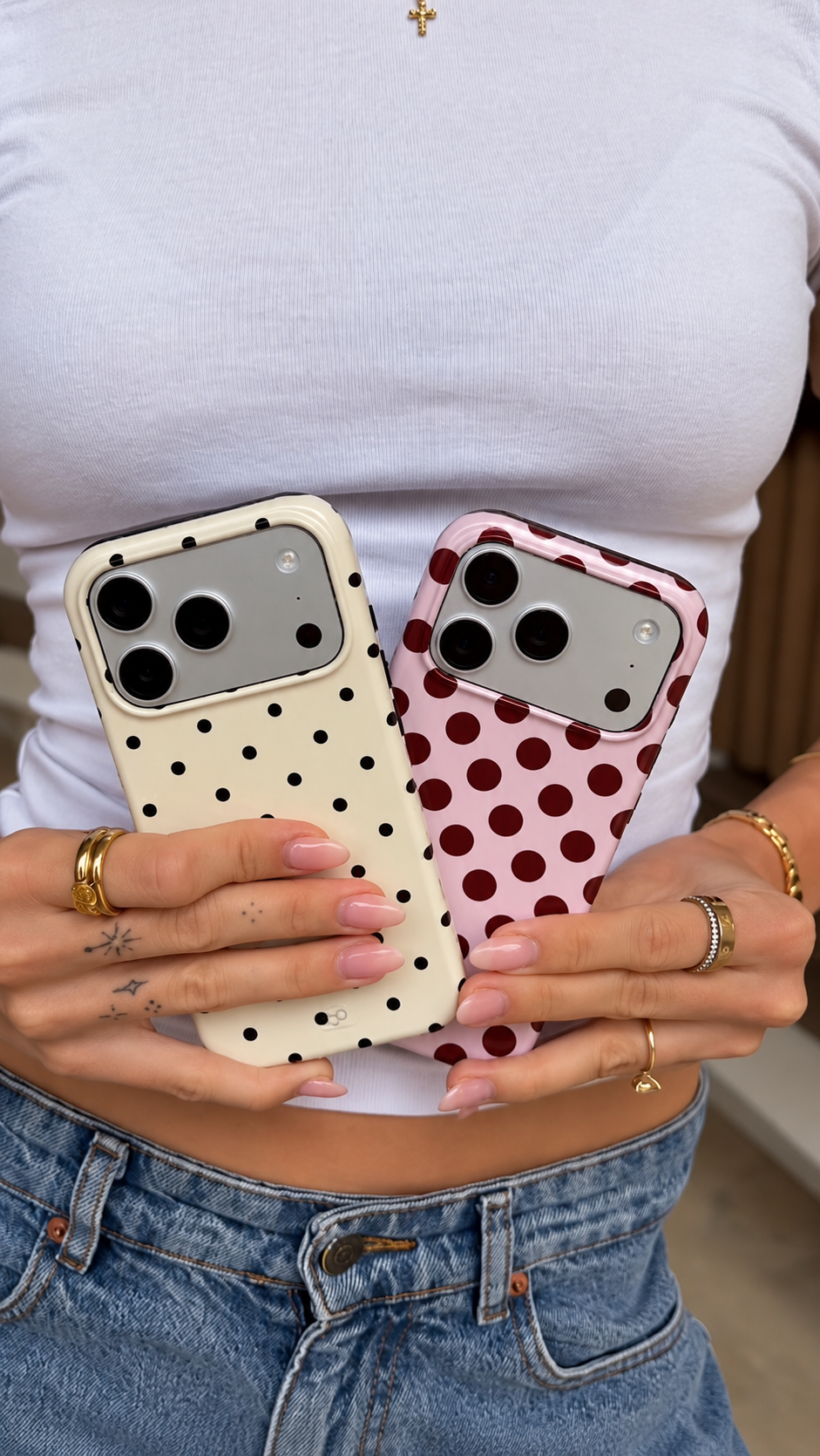 Two ARTSYPOD polka-dot phone cases held together: cream with black dots and pink with burgundy dots